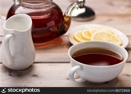 Glass teapot and teacup. Glass teapot and teacup on wooden background