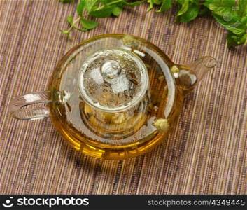 glass teapot with hot green tea