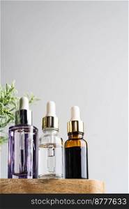 Glass tubes of cosmetic product with serum on wooden shelf on a white background, bottom view. Skin care concept. Glass tubes of cosmetic