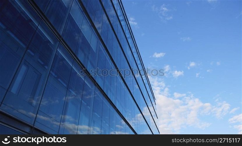 Glass wall of an office building, reflections of clouds