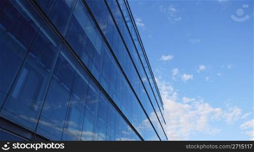 Glass wall of an office building, reflections of clouds