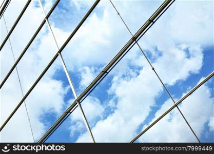Glass wall of business center and sky reflection, may be used as background