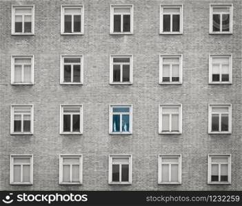 Glass window of skyscraper apartment or hotel building. Exterior brick wall of residential building. Architecture design. Window of building texture background. Gray and white vintage building.