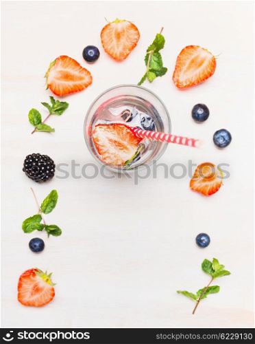 Glass with berries lemonade and ingredients on white wooden background, top view. Detox drink, diet and health food concept