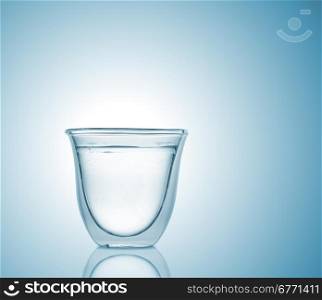 Glass with carbonated water on blue gradient background, high depth of field, studio shot