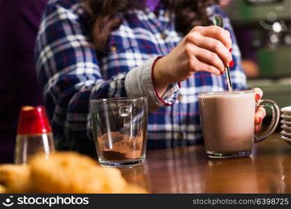 Glass with cocoa with milk on the table in cafe. Cocoa drink cooking