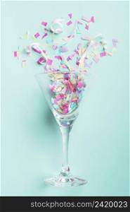 glass with confetti turquoise background