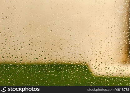 Glass with drops of rain water close up