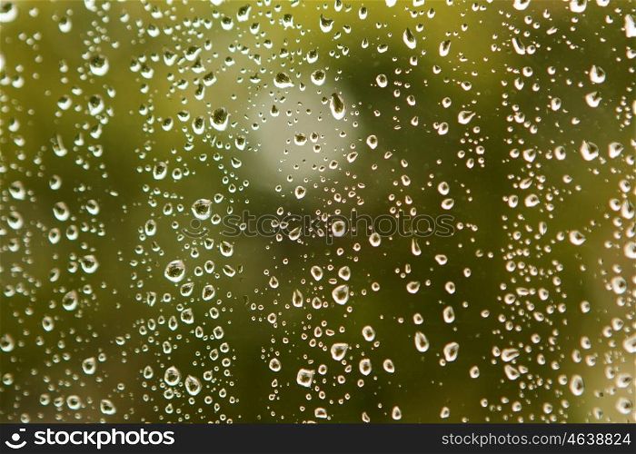 Glass with drops of rain water close up