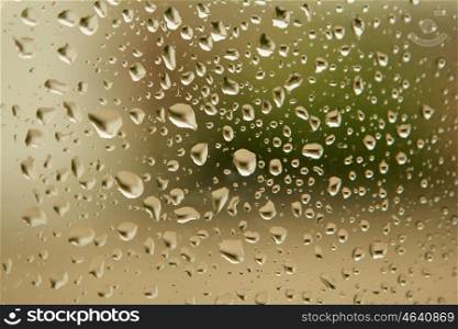 Glass with drops of rain water close up
