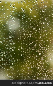 Glass with drops of rain water close up