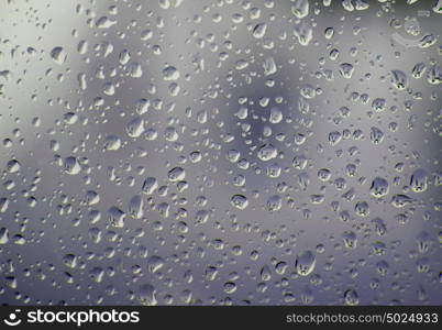 Glass with drops of rain water close up