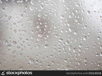 Glass with drops of rain water close up