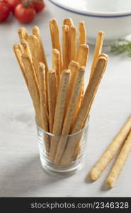 Glass with fresh baked Italian bread sticks as a side dish or snack