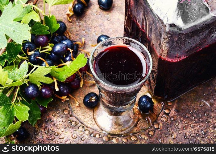 Glass with homemade liqueur from black currant. Alcohol currant drink