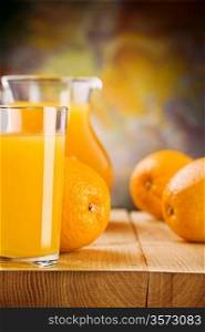 glass with juice and oranges