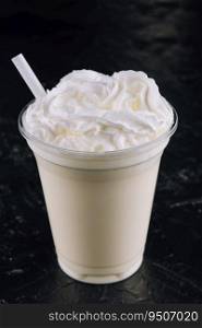 Glass with white milkshake and cream