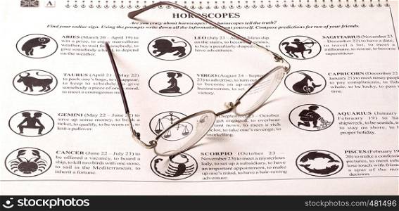 glasses and newspaper horoscope on the table