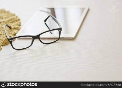 glasses and tablet. glasses and tablet on a white table