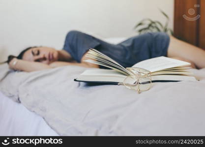 glasses book near sleeping woman