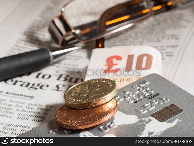 Glasses, coins, credit cards and banknotes on newspaper.Macro shot