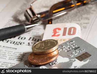 Glasses, coins, credit cards and banknotes on newspaper.Macro shot