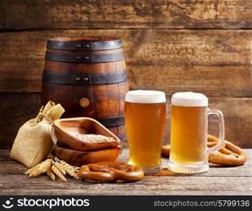 glasses of beer with barrel on wooden background