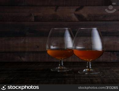 Glasses of brandy cognac shot on wooden table background