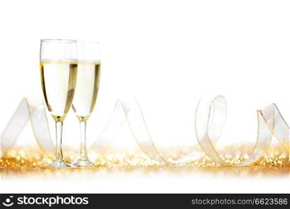 Glasses of ch&agne and ribbon on golden glitters isolated on white