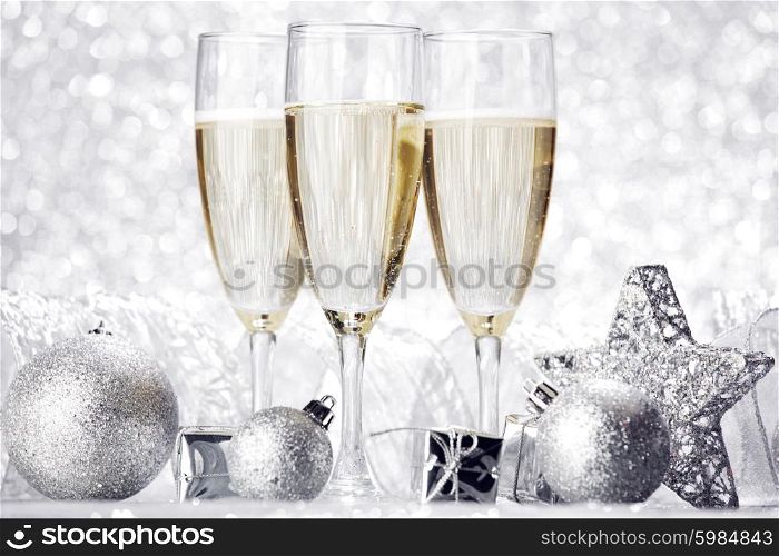 Glasses of champagne and christmas decoration on silver background