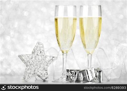 Glasses of champagne and christmas decoration on silver background
