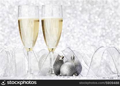 Glasses of champagne and christmas decoration on silver background. Champagne and decoration