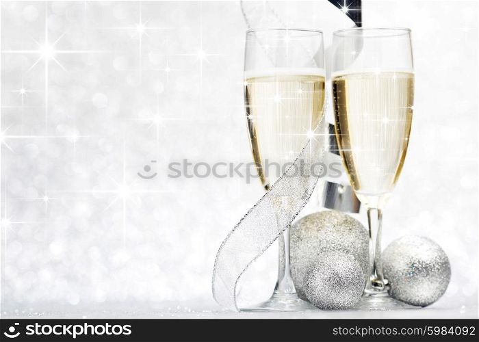 Glasses of champagne and christmas decorative balls on glitter background