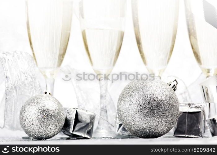 Glasses of champagne and christmas gifts on silver background