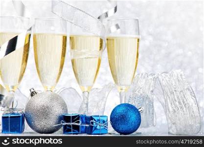Glasses of champagne and decorative christmas balls on glitter background
