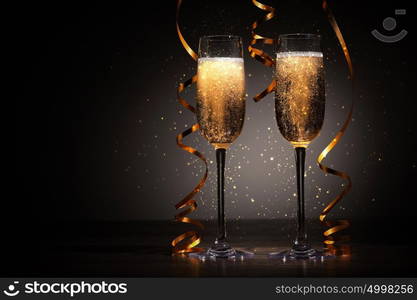 Glasses of champagne at new year party. Two champagne glasses ready to bring in the New Year