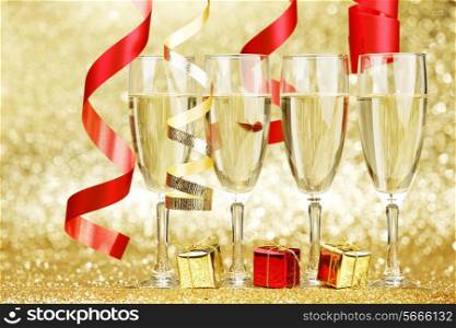 Glasses of champagne colorful ribbons on glitter background