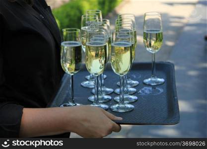 Glasses of champagne on a tray, served on a wedding reception
