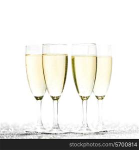 Glasses of champagne on glitters isolated on white background