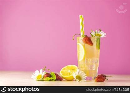 Glasses of cold icy refreshing drink with lemon and strawberry. Bright pink background. Fresh cocktail drinks with ice fruit, herb and chamomile decoration.