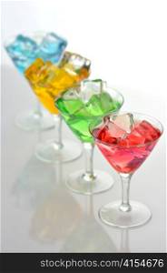 glasses of colorful drinks with ice cubes