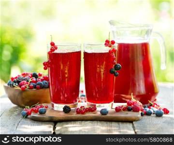 glasses of fresh fruit drinks with fresh berries on wooden table