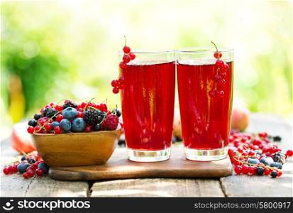 glasses of fresh fruit drinks with fresh berries on wooden table