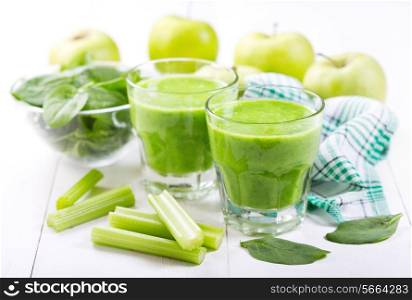 glasses of green juice with apple and spinach on wooden table