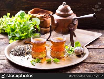 glasses of hot tea with teapot on wooden background