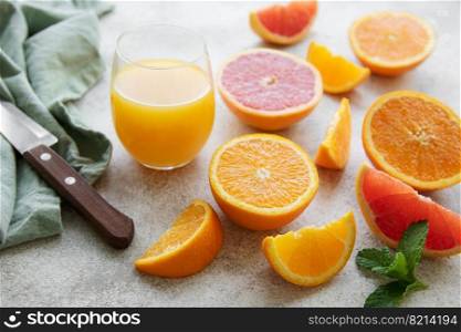 Glasses of juice and fresh citrus fruits