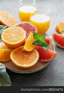 Glasses of juice and fresh citrus fruits