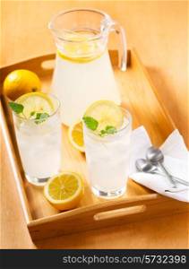 glasses of lemonade with fresh fruits on a tray