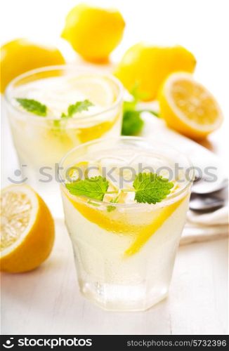 glasses of lemonade with fresh fruits on wooden table