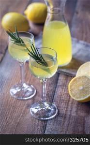 Glasses of limoncello on the wooden background